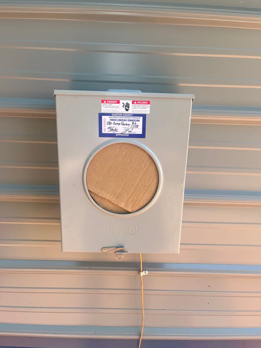 New electrical meter socket installed on a metal wall