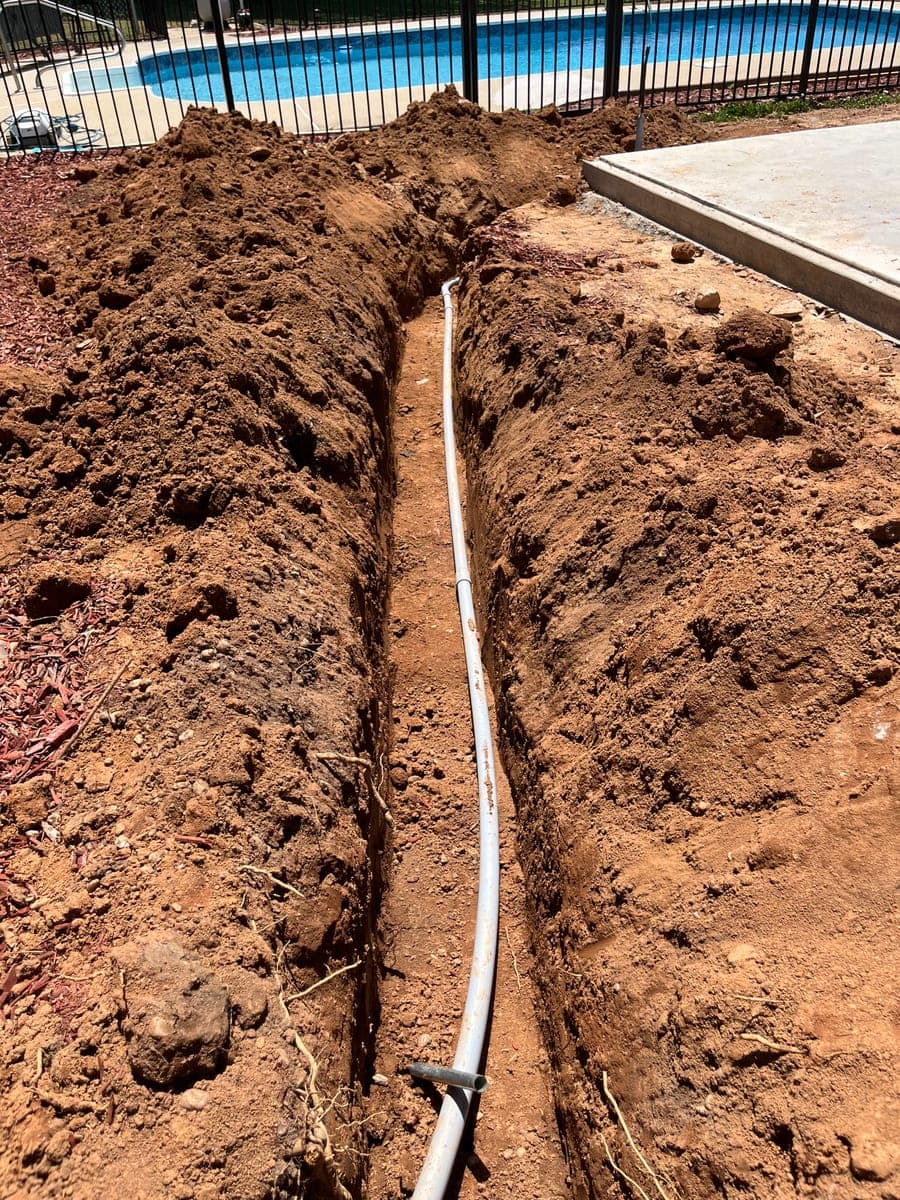 Trench with underground electrical conduit for residential service work