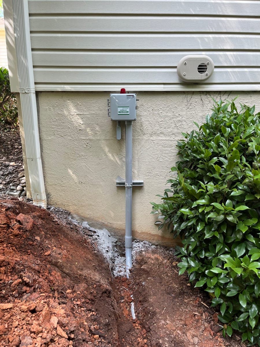 Exterior conduit and electrical service equipment installed near a home